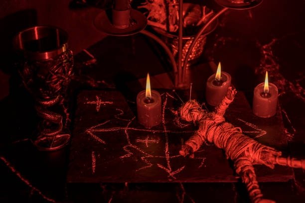 Dos figuras atadas con cuerda entre velas encendidas